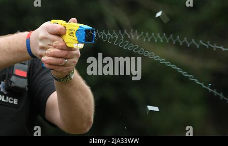 Photo du dossier 26/02/13 d'un policier démontrant l'utilisation d'un Taser, comme la police britannique des transports est devenue la première force au Royaume-Uni à armer des agents bénévoles avec des Tsers. Banque D'Images