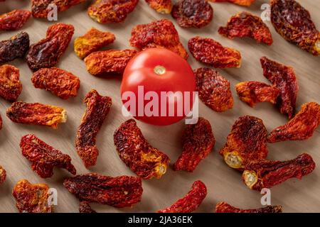 Tomates fraîches et tomates séchées sur fond de bois Banque D'Images