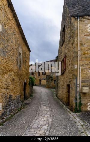 Beynac-et-Cazenac, France - 12 mai 2022 : rue pavée étroite avec maisons en pierre pittoresques dans le village historique de Beynac-et-Cazenac Banque D'Images