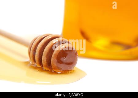 Le miel s'égoutte du pot à miel dans un pot en verre, vue de dessus. Concept d'alimentation saine. Banque D'Images