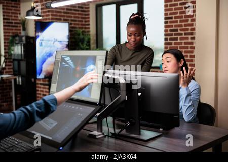 Les développeurs de jeux discutent du flux de travail d'équipe afin d'obtenir de bons résultats tout en concevant de l'art numérique. Les employés des agences créatives remue-méninges des idées de conception de projet tout en développant 3D modèles. Banque D'Images