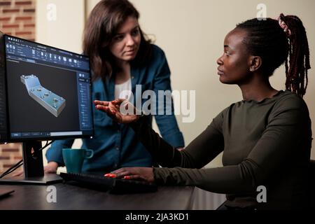 3D artiste numérique collaborant avec un collègue afin de résoudre des difficultés techniques. Le chef d'équipe du service de production indique un problème de géométrie du maillage et fournit une solution à un collègue. Banque D'Images