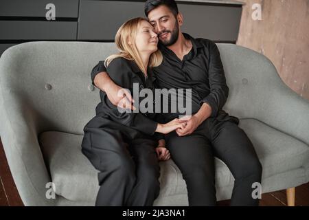 Heureux couple assis sur le canapé. Banque D'Images