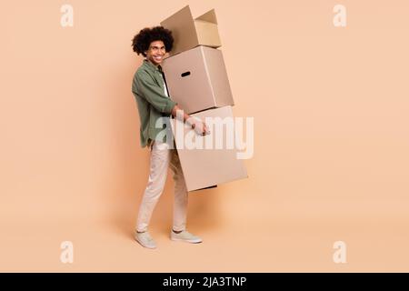 Portrait du profil de la personne positive tient les boîtes d'expédition de colis isolées sur fond beige Banque D'Images