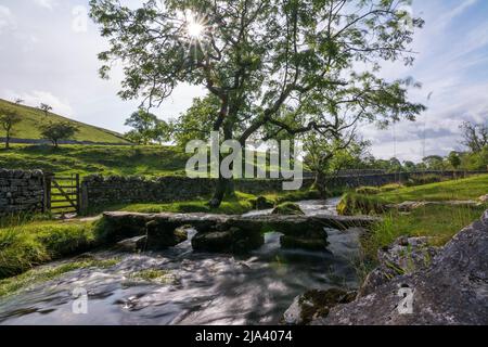 Le matin, un coucher de soleil sur le ruisseau s'est enjamci de Malham Cove dans les Yorkshire Dales. Visité pendant la longue distance de marche de Dales High Way. Banque D'Images