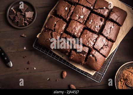 Brownies au chocolat frais sur une table en bois sombre. Délicieux dessert au chocolat maison, tarte au chocolat et ingrédients, vue sur le dessus, espace de copie. Banque D'Images