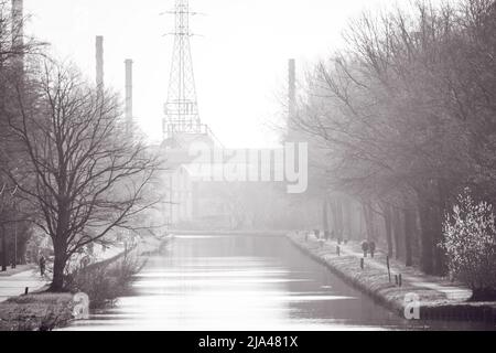 Paysage industriel noir et blanc avec lignes électriques, arbres, route et canal ou voie navigable. Photo de haute qualité Banque D'Images