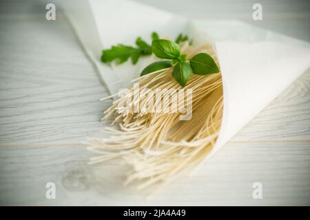 nouilles aux œufs séchées faites maison dans un sac de papier au basilic Banque D'Images