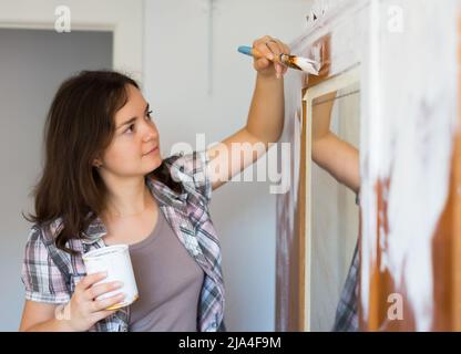 Femme peint le placard et fait des réparations dans l'appartement Banque D'Images