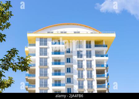 Vue sur un beau bâtiment résidentiel au ciel bleu et à la verdure. Nouvelle maison inhabitée. Banque D'Images