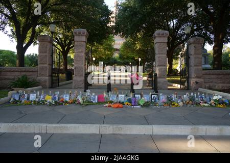 Austin, États-Unis. 26th mai 2022. Des photos de victimes tuées dans les fusillades de l'école Uvalde sont vues entourées de fleurs et de bougies à la porte d'entrée du bâtiment du Capitole du Texas à Austin, Texas, États-Unis, le 26 mai 2022. Credit: Bo Lee/Xinhua/Alay Live News Banque D'Images