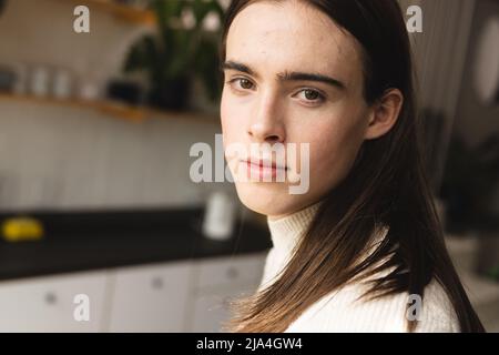 Gros plan portrait d'une femme trans non binaire dans la cuisine à la maison Banque D'Images