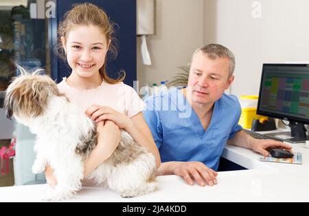 Bonne fille avec le conseil de chien par vétérinaire Banque D'Images