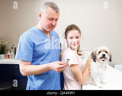 Bonne fille avec le conseil de chien par vétérinaire Banque D'Images