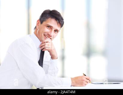 Beau homme d'affaires souriant au bureau Banque D'Images