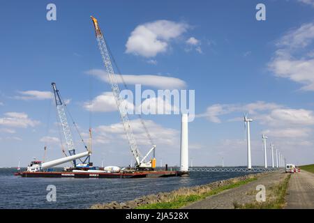 Lelystad, pays-Bas - 22 avril 2022 : navire-grue et navire de ravitaillement chargé de la démolition de l'ancienne éolienne offshore Banque D'Images