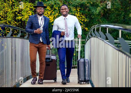 Deux partenaires d'affaires afro-américains se rendent à l'aéroport pour une conférence internationale de réunion d'affaires Banque D'Images