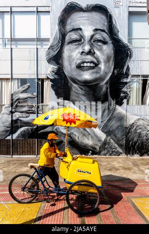 Un vendeur de crème glacée passe par Une grande murale dans le district de Barranco, Lima, Pérou. Banque D'Images