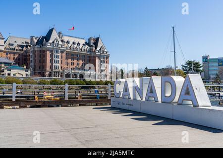 Victoria, C.-B., Canada - 14 avril 2021 : Canada panneau, port intérieur de Victoria. Bâtiments historiques en arrière-plan sur ciel bleu. Hôtel Fairmont Empre Banque D'Images