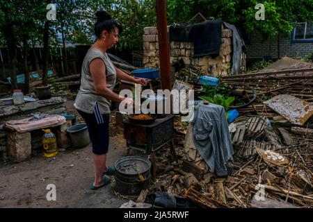 Siversk, Ukraine. 27th mai 2022. Une femme qui cuisine le chou dans la cour de sa maison, la ville n'a pas de gaz, d'eau et d'électricité. Siversk est une ville de 11 000 habitants connue pour son usine de briques, située dans la région de Donetsk. À l'heure actuelle, de nombreuses personnes ont évacué la ville fantôme en raison de sa proximité avec la ligne de front qui se rapproche chaque jour. Les quelques personnes qui vivent encore dans la ville ont leurs maisons sans eau, gaz et électricité. (Photo de Rick Mave/SOPA Images/Sipa USA) crédit: SIPA USA/Alay Live News Banque D'Images