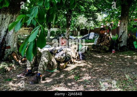 Verkhnokmayanske, Ukraine. 27th mai 2022. Les soldats se reposent sous les arbres. Verkhnokmayanske est une petite ville de la région de Donetsk. La ville souffre d'une pénurie de nourriture et de médicaments, de gaz, d'eau et d'électricité. Par conséquent, la première ligne se rapproche chaque jour de la ville et la plupart des civils ont fui. Crédit : SOPA Images Limited/Alamy Live News Banque D'Images