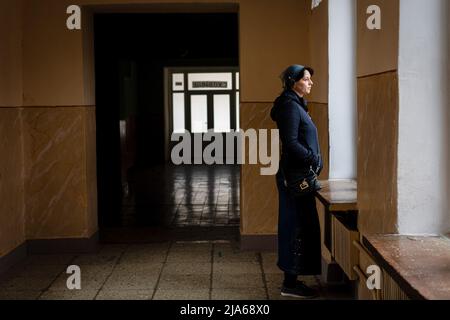 Polyana, Zakarpattia, Ukraine. 11th avril 2022. Une femme déplacée regarde à travers une fenêtre à l'école où elle est abritée à Polyana. Une ville généralement remplie de touristes en raison de la beauté naturelle environnante, des pistes de ski et des eaux thermales, elle est devenue un refuge sûr pour de nombreux Ukrainiens déplacés par la guerre. Depuis le début de l'invasion russe de l'Ukraine, de nombreux réfugiés recherchent un abri dans la région de Zakarpattia, l'une des régions les plus pauvres du pays qui reçoit aujourd'hui environ 15 000 000 personnes par jour d'autres régions de l'Ukraine. Les autorités locales, ainsi que les entreprises Banque D'Images