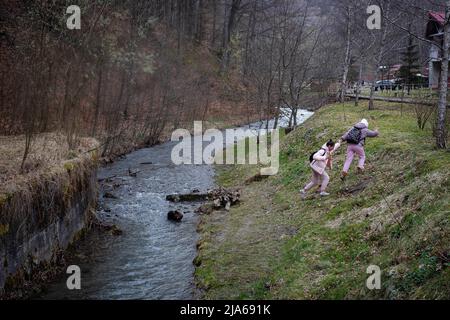 11 avril 2022, Polyana, Zakarpattia, Ukraine: Deux filles tentent de grimper sur une rive dans la ville balnéaire de Polyana. Polyana est généralement rempli de touristes en raison de la beauté naturelle environnante, des pistes de ski et des eaux thermales. Elle est devenue un refuge pour de nombreux Ukrainiens déplacés par la guerre. Depuis le début de l'invasion russe de l'Ukraine, de nombreux réfugiés ont cherché refuge dans la région de Zakarpattia, l'une des régions les plus pauvres du pays qui reçoit aujourd'hui environ 15 000 000 personnes par jour d'autres régions de l'Ukraine. Les entreprises, la société civile et les autorités locales travaillent ensemble avec les ens Banque D'Images