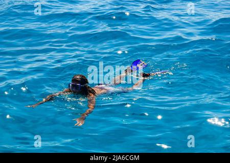 L'homme africain est engagé dans la plongée en apnée. Un homme en masque et nageoires nage sur la mer. Vue de dessus. Hurghada, Egypte - Mars 2022 Banque D'Images