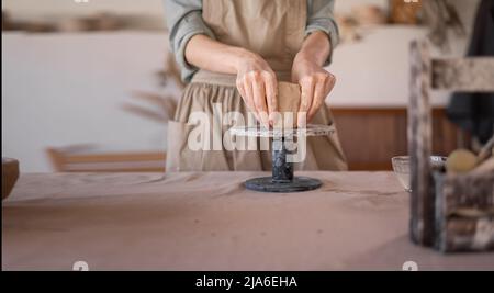 femelle potter travaille avec l'argile, gros-up des mains femelles tenir un morceau d'argile humide dans ses mains. Le potter crée le produit. La formation de Banque D'Images