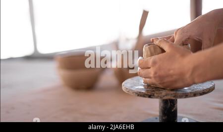 une femelle potter travaille avec l'argile, gros-up des mains femelles tenir un morceau d'argile humide dans ses mains. Le potter crée le produit. La formation de Banque D'Images