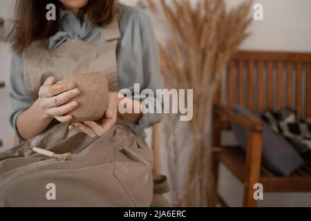 Bricolage gros plan d'une femme créative sculptant un bol d'argile brute dans un atelier de poterie pendant une classe de maître ou un atelier. Artisanat et artisan Banque D'Images