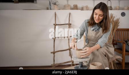 processus créatif de la femme artiste de travaux d'aiguille est engagée dans le moulage et la modélisation manuelle de la poterie. Une table de travail dans un atelier où un potier travaille Banque D'Images