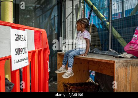 Enfant assis à l'extérieur de la banque alimentaire pour les familles souffrant de difficultés financières. Lewisham Donation Hub, Londres , Angleterre . Banque D'Images