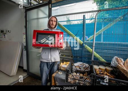 Un homme qui se fait un micro-ondes dans une banque alimentaire locale a donné des appareils de cuisine à un moment où les finances sont pressés comme jamais auparavant à Lewis Banque D'Images