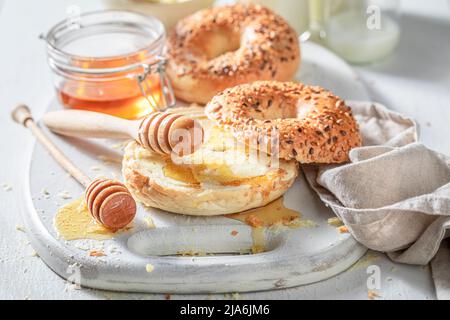 Bagels dorés doux et sains avec du lait et du miel. Petits pains sucrés frais pour le petit-déjeuner. Banque D'Images
