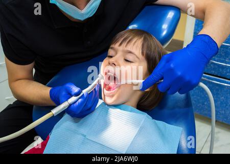 Stomatologue traitant les dents de l'enfant du patient. Médecine, dentisterie et concept de soins de santé Banque D'Images