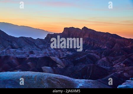 La Vallée de la mort à l'aube avec la lumière dorée qui fait des montagnes de couleur Banque D'Images