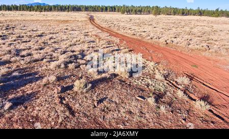 Vue aérienne de la petite route de terre traversant les plaines désertiques Banque D'Images