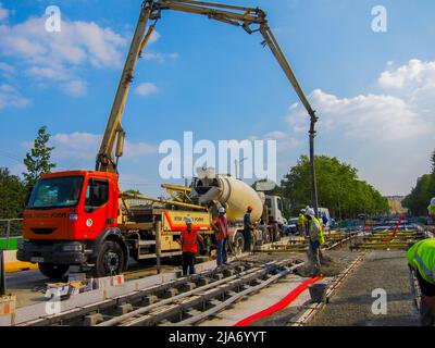 Paris, France, ouvriers de la construction appliquant du béton sur les voies de tramway de la rue Banque D'Images