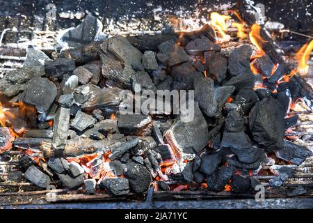 Flamme du feu provenant du charbon de bois brûlé dans le feu de camp sur le gril Banque D'Images