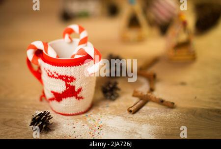 mug en laine isolante avec cerf brodé sur la table en bois Banque D'Images