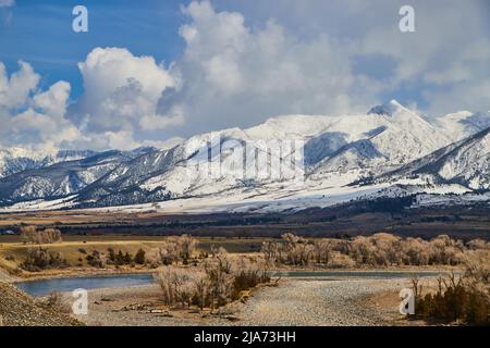 Belles montagnes blanches enneigées avec champs de source et rivière en premier plan Banque D'Images