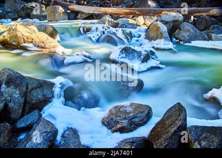 Début du printemps, détail des chutes de rivière en cascade sur des rochers couverts de neige et de gel Banque D'Images