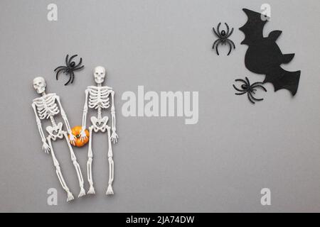 squelettes avec citrouille, chauve-souris et araignées noires sur fond gris. halloween concept. Banque D'Images