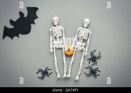 squelettes avec citrouille, chauve-souris et araignées noires sur fond gris. halloween concept. Banque D'Images