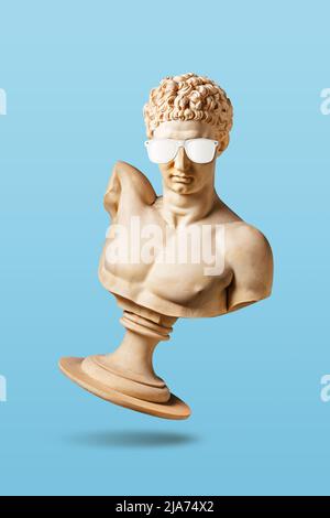 Concept créatif avec ancienne statue en lunettes de soleil sur fond bleu clair. Concept de fête minimal. Banque D'Images