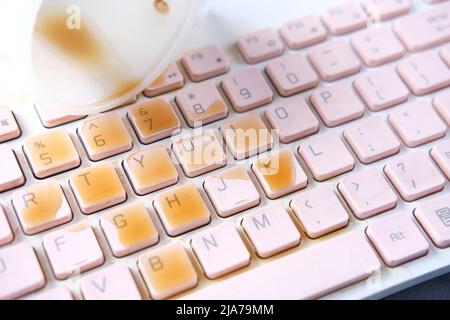 le café déborde sur le clavier de l'ordinateur portable. gros plan Banque D'Images