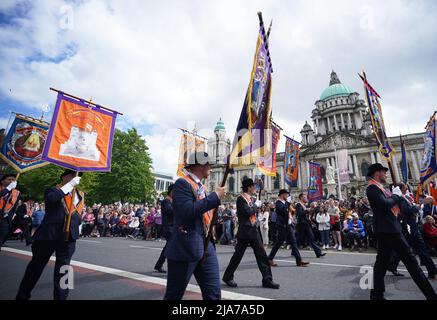 Les marcheurs passent devant l'hôtel de ville de Belfast, pendant le défilé du centenaire de l'Irlande du Nord pour commémorer la création de l'Irlande du Nord. Date de la photo: Samedi 28 mai 2022. Banque D'Images