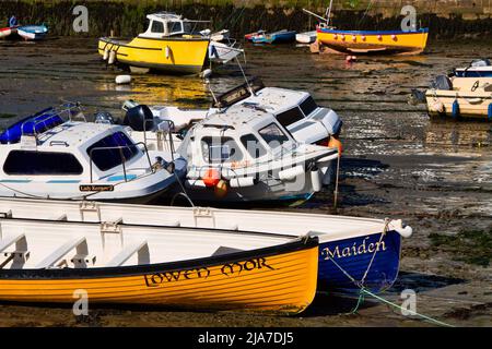 Petits bateaux de pêche et deux gigs dans le port de Porthleven à marée basse Banque D'Images