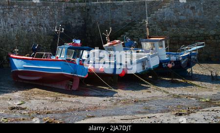 Petits bateaux de pêche dans le port de Porthleven à marée basse Banque D'Images